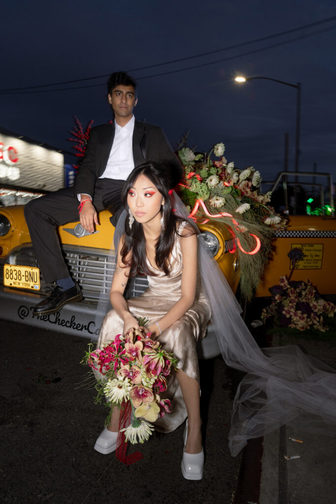 Brooklyn editorial engagement session with couple in Chinatown taxi with floral installation