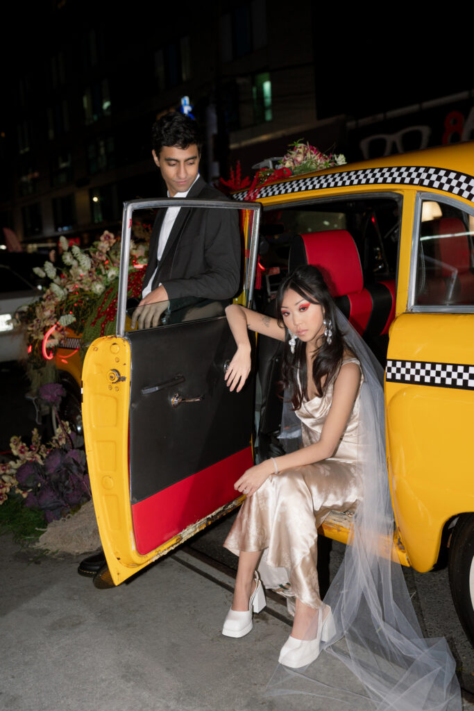 Brooklyn editorial engagement session with couple in Chinatown taxi with floral installation
